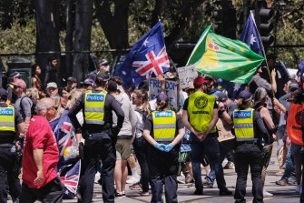 Police observe the protest in Melbourne on Saturday.