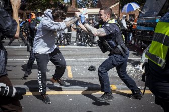 A police officer uses capsicum spray on a protester during Saturday’s anti-lockdown rally.