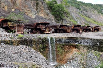 Heavy trucks sit rusting on the edges of Panguna copper mine, closed in 1989 as a result of sabotage.