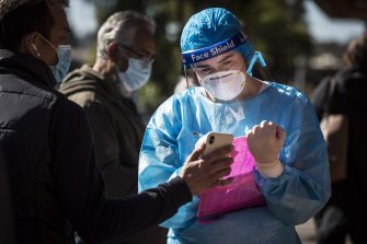 A woman takes down details at a COVID-19 testing clinic at Campsie on Friday.