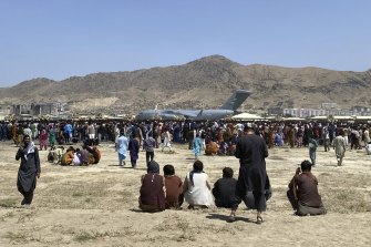 Hundreds of people gather near a US Air Force transport plane at the international airport in Kabul, Afghanistan on Monday.