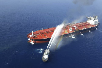 An Iranian navy ship hoses down a fire on a tanker in the Gulf of Oman on June 13. 