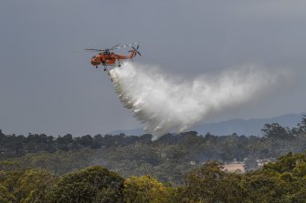 An Aircrane helicopter drops water on a fire in Mill Park on Monday.