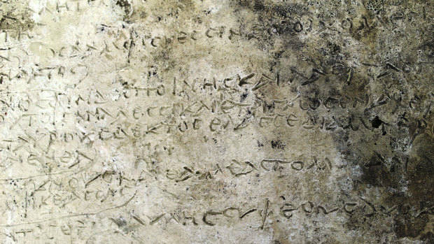 A slab inscribed with verses from the Odyssey's Book written in ancient Greek.
