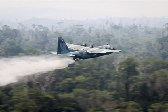 A C-130 Hercules aircraft dumps water to fight fires burning in the Amazon rainforest.