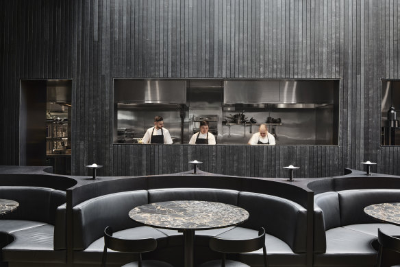 Saint Dining features booths with leather seats surrounding marble tables .