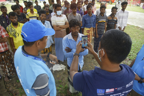 A Rohingya man has his photo taken as he is registered at a temporary shelter in Pidie in the Indonesian province of Aceh.