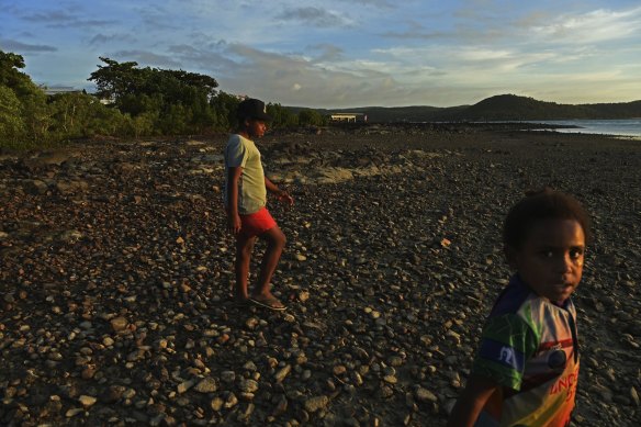 Donniella Warria (left) and Ikokolela Ronsen (right) walk on the Bach Beach in the late afternoon on Thursday Island. 