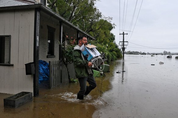 Ben Sullivan retrieves a few last items before he evacuates his inundated home in Windsor on Monday morning.