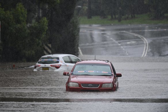 Abandoned cars in floodwaters on Henry Lawson Drive in Georges Hall, Sydney. 