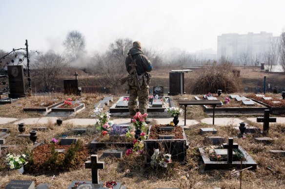 A Ukrainian serviceman stands in the cemetery on Wednesday after the funeral of his comrade Vladyslav Buvalkin in Kyiv, Ukraine.