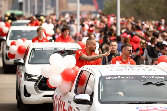 Lance Franklin and Tom Papley of the Sydney Swans wave during a small part of the parade last year which was conducted on land.
