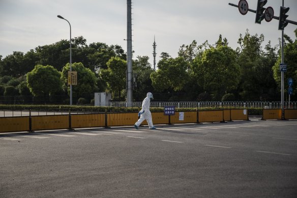 A person walks past a security checkpoint as several city blocks are sealed off due to COVID-19 in a suburb of Shanghai last week. On Thursday, officials ordered a lockdown of the entire hub city of Chengdu.