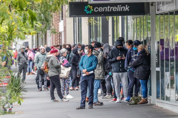 People queue outside a Centrelink office in South Melbourne. Almost a million Australians have lost jobs during the coronavirus pandemic. 