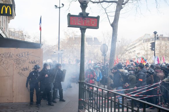 Demonstrators face riot police during a protest against government plans to revamp the pension system, in Paris, France, on Saturday, February 11, 2023. 