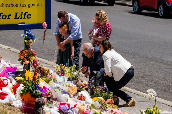 Prime Minister Scott Morrison says a prayer alonside wife Jenny at Hillcrest Primary School on Saturday. With them is member for Braddon Gavin Pearce.