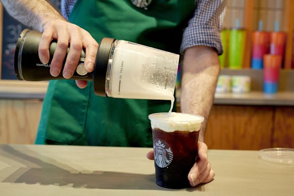 A Starbucks barista uses a portable blender to make cold foam in New York. 