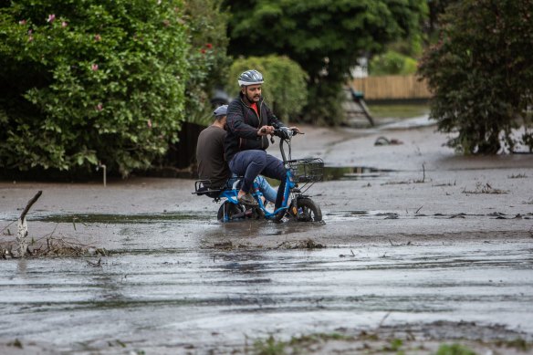 Two people ride through flood waters from the Maribyrnong River in October 2022.