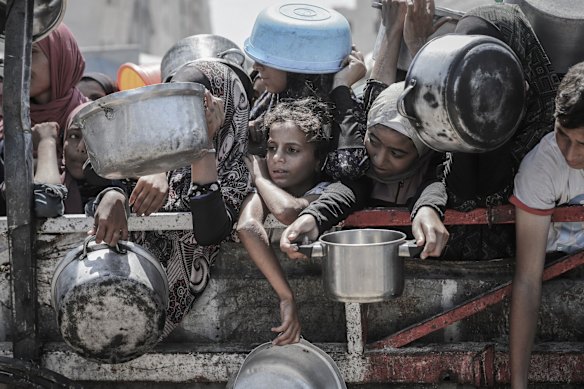 Warga Palestina menunggu untuk mengumpulkan makanan gratis dari dapur amal di Gaza City.
