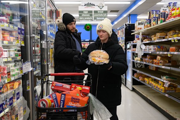 住民は嵐の中、物資を買いに行く。