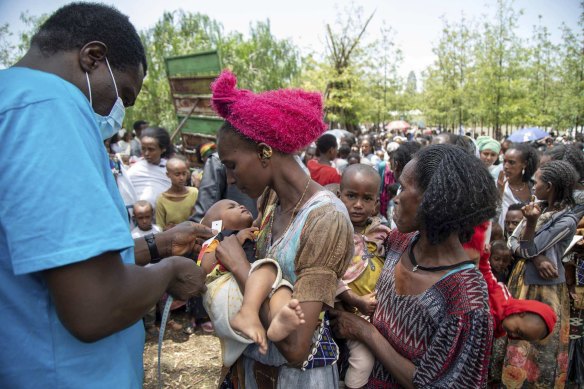 UNICEF nutrition specialist Joseph Senesie (left) screens a child for malnutrition in Adikeh, in the Wajirat district of the Tigray region of northern Ethiopia in 2021.