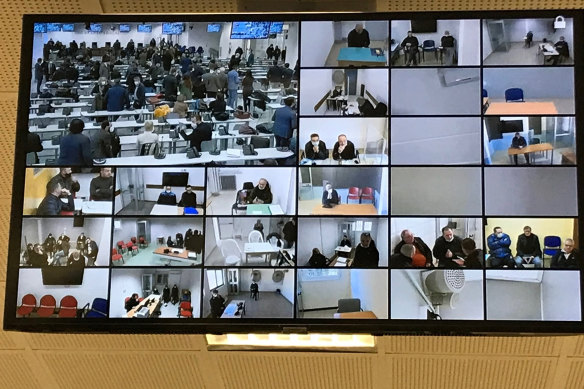 A screen anchored to the ceiling shows the participants following the first hearing of a maxi-trial against more than 300 defendants of the ’ndrangheta crime syndicate.