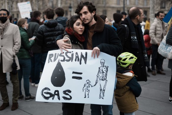 A European couple holding a placard during a demonstration against the Russian invasion of Ukraine.