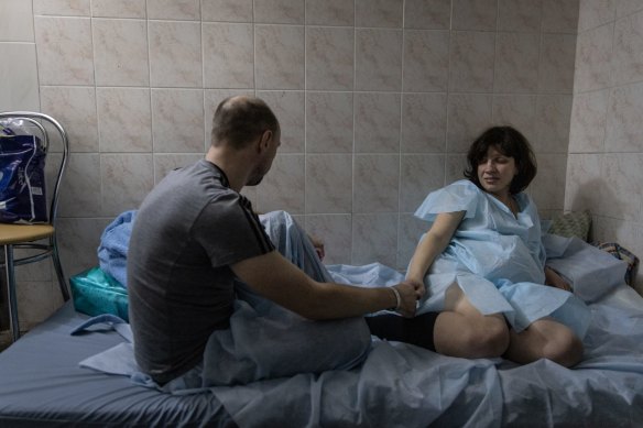 A man holds his partners hand as she has contractions in the bomb shelter of a maternity hospital in Kyiv, Ukraine, on Wednesday.