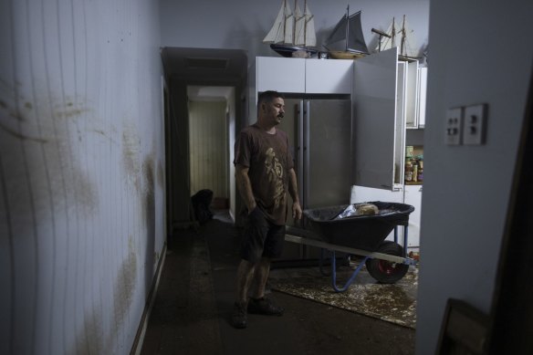 Matt Cutting stands amongst the ruins of his home after flooding reach the second story. 