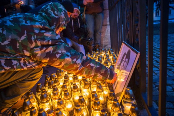 People place light tributes during a silent protest in memory of murdered journalist Jan Kuciak and his girlfriend Martina Kusnirova in Bratislava, Slovakia.