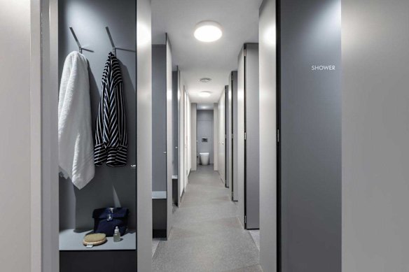 Shared bathrooms have multiple toilets and shower cubicles with changing areas.