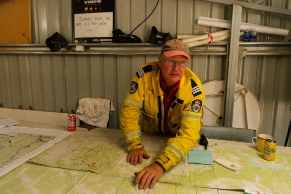 Adaminaby RFS captain Bob Killip outlines the state of the fire at Shannons Flat on Friday afternoon. 