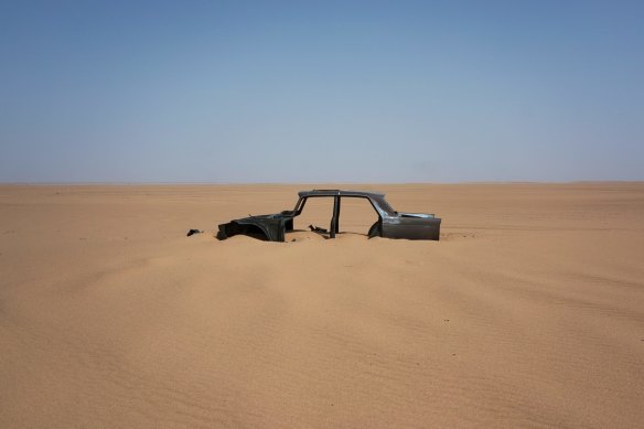 The frame of an abandoned Peugeot rests in Niger's Tenere desert. Once a well-worn roadway for  tourists, the 4500-kilometre route is a favoured path for migrants heading north. 