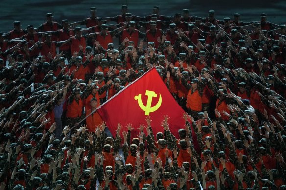 Performers gather around a Communist Party flag during a gala show for the 100th anniversary of the CCP. 