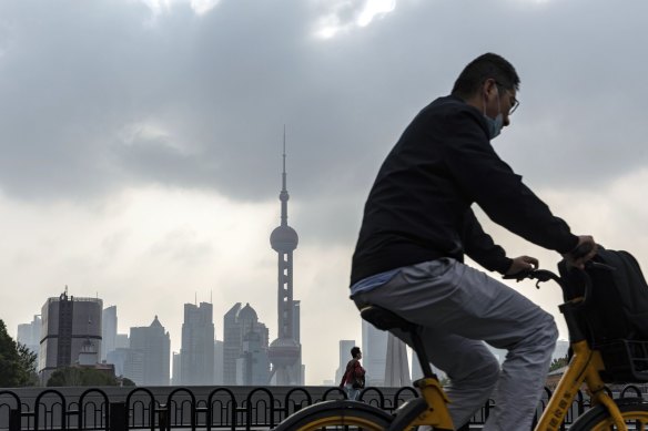 A cyclist passes buildings in Pudong’s Lujiazui Financial District in Shanghai. Chinese President Xi Jinping signalled no change in direction for main risk factors dragging down China’s economy, including the country’s strict COVID rules.