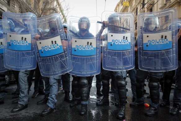 Police officers face demonstrators protesting on the sidelines of the G20 meeting in Italy.