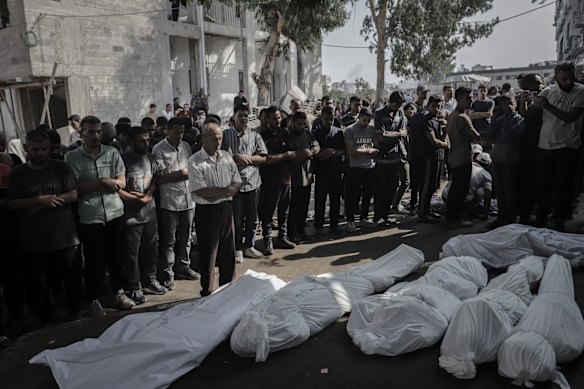 Palestinians pray beside the bodies of those killed during an Israeli airstrike at the Al-Shifa hospital in Gaza City, on Wednesday.