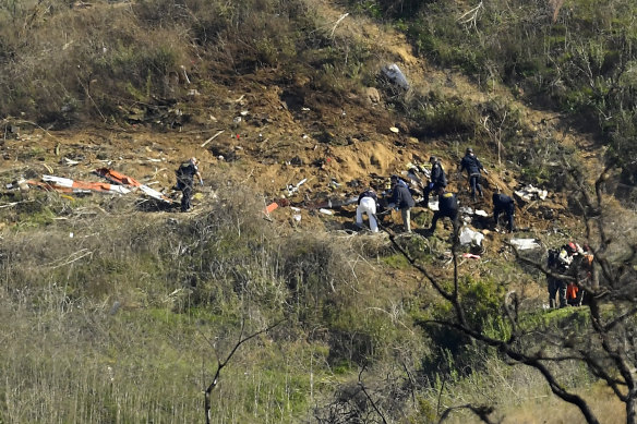 Investigators work the scene of a helicopter crash in California that killed nine people, including former NBA basketball player Kobe Bryant and his 13-year-old daughter, Gianna. 