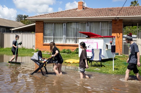 Local residents walk through a flooded street in Shepparton.