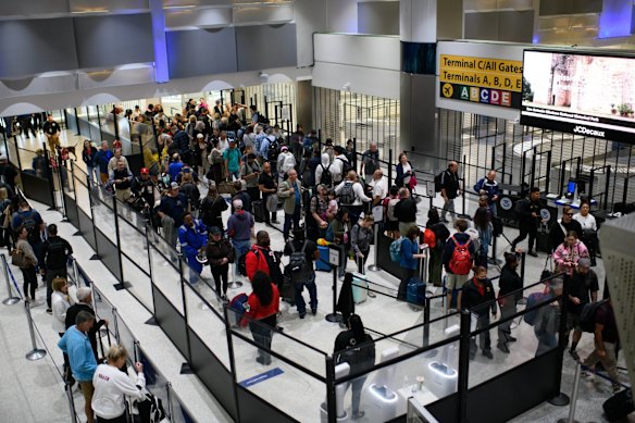 Travellers wait in line at a Texas airport after airlines cancelled flights.