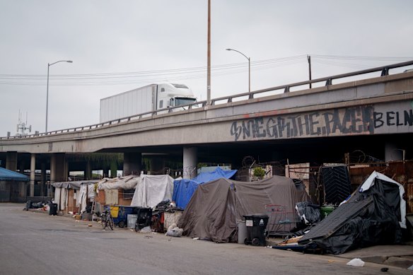 Pessoas que dormem mal armam suas barracas perto de um viaduto nas ruas de Los Angeles, Califórnia. 