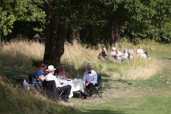 Audience members picnic in the bucolic grounds of Glyndebourne Opera House.