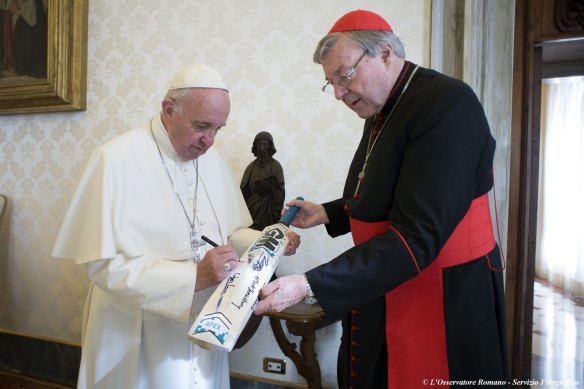 Pope Francis receives a cricket bat from Cardinal George Pell in 2015.