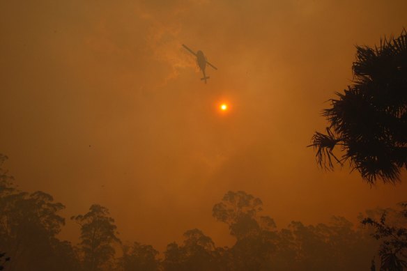 Firefighters protect property from a bushfire on Lakes Way, North of Forster near the junction of the Pacific Highway.