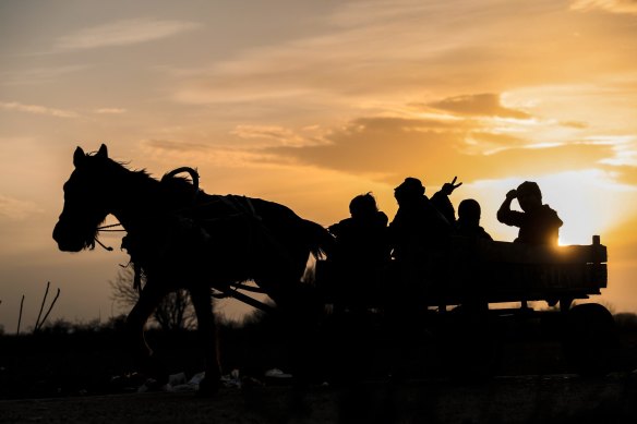 A migrant flashes a victory sign as he rides with others in a cart near the Turkish-Greek border on Sunday.