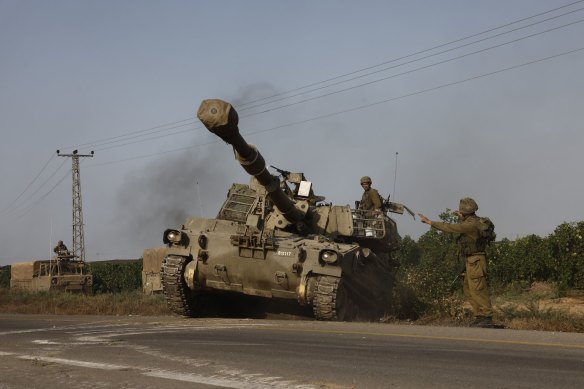 Israeli security forces aboard a self-propelled canon move towards the border with Gaza outside Sderot, Israel.