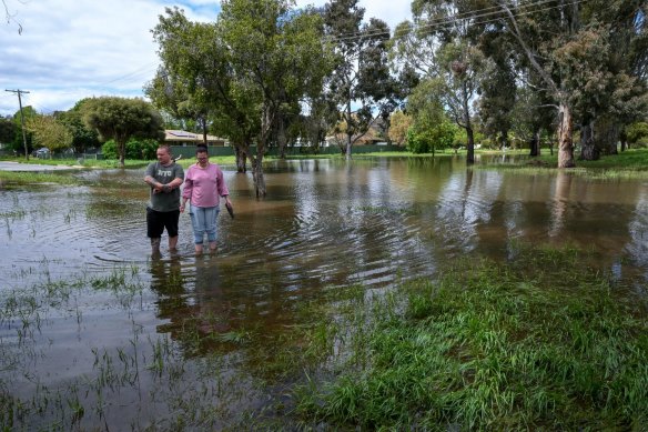 Local residents walk through flooded Howe Street in Mooroopna on Saturday.