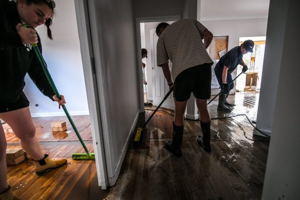 Friends and family help with the clean-up at Darcy and Hannah Taylor’s home in Rochester.