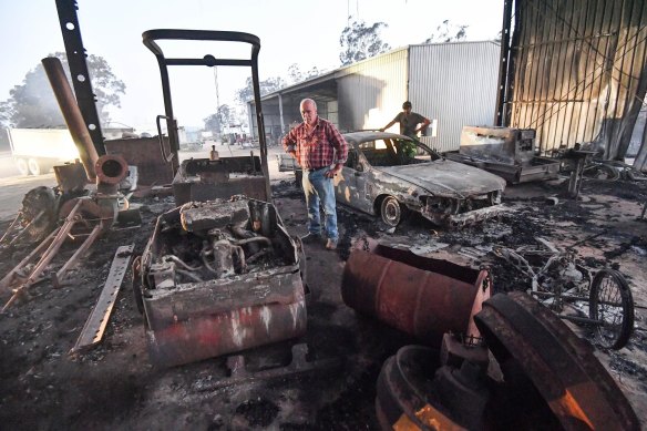 Peter Riley (front) and his son-in-law Simon Evvage at their fire damaged Clifton Creek property in Victoria.