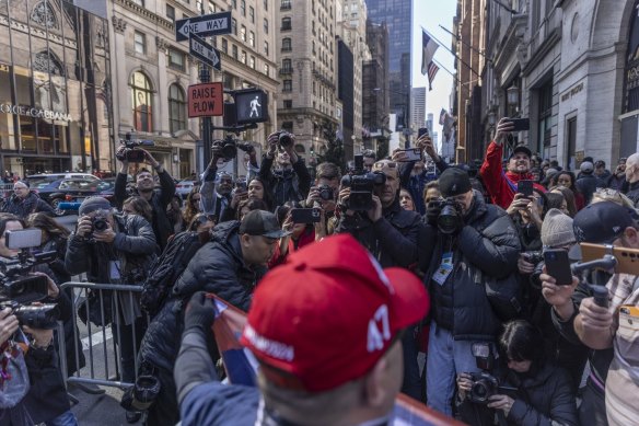 Members of the media photograph a supporter of Donald Trump outside Trump Tower in New York.